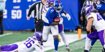 New York Giants player Deonte Banks runs the ball as Minnesota Vikings player Ivan Pace Jr. tackles him.