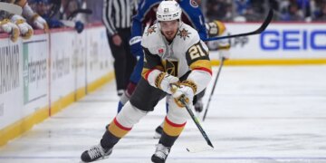 Vegas Golden Knights player Brett Howden with the puck, pursued by Colorado Avalanche player Brock Nelson.