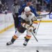 Vegas Golden Knights player Brett Howden with the puck, pursued by Colorado Avalanche player Brock Nelson.