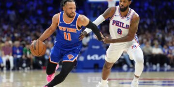Knicks guard Jalen Brunson (11) drives against 76ers forward Paul George (8) during Game 4 on May 10, 2026.