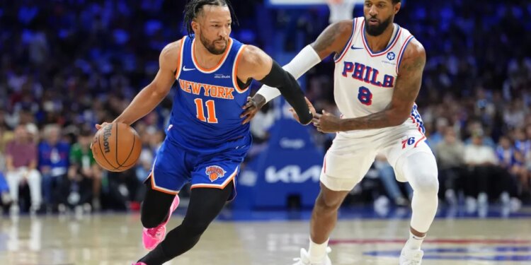 Knicks guard Jalen Brunson (11) drives against 76ers forward Paul George (8) during Game 4 on May 10, 2026.