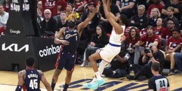 New York Knicks guard Mikal Bridges (25) shoots as Cleveland Cavaliers guard James Harden (1) defends.