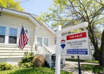 A single-family home with a "For Sale" sign in the front yard.