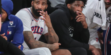 Andre Drummond and Joel Embiid on the bench during an NBA Playoffs game.