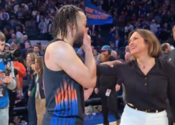 Jalen Brunson with a woman on a basketball court.