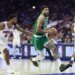 Boston Celtics player Jayson Tatum dribbles the ball down the court while being guarded by a Philadelphia 76ers player.