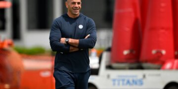 Robert Saleh, head coach for the Tennessee Titans, smiling with his arms crossed during the NFL team's rookie minicamp.