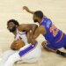 76ers center Joel Embiid (21) grimaces as he and Knicks wing Mikal Bridges (25) fight for control of the ball during Game 4 of the second round on May 10, 2026.