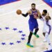 New York Knicks center Karl-Anthony Towns (32) passes the ball as Philadelphia 76ers forward Paul George (8) defends.