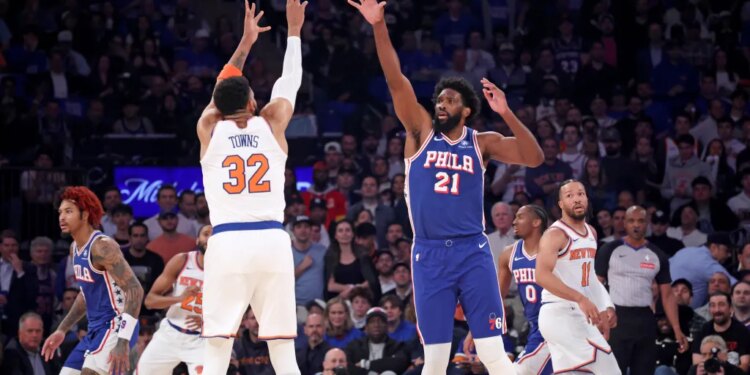 New York Knicks center Karl-Anthony Towns #32 puts up a shot over Philadelphia 76ers center Joel Embiid #21 in the first quarter of an NBA playoff game.