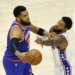 New York Knicks center Karl-Anthony Towns (32) passes the ball as Philadelphia 76ers forward Paul George (8) defends.