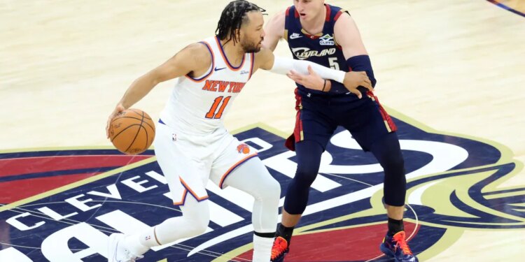 New York Knicks guard Jalen Brunson (11) drives down court as Cleveland Cavaliers guard Sam Merrill (5) gives chase during the second quarter.
