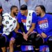 New York Knicks guards Mikal Bridges, Josh Hart, and Jalen Brunson sitting on the bench.