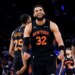 New York Knicks center Karl-Anthony Towns smiles after scoring during a game.
