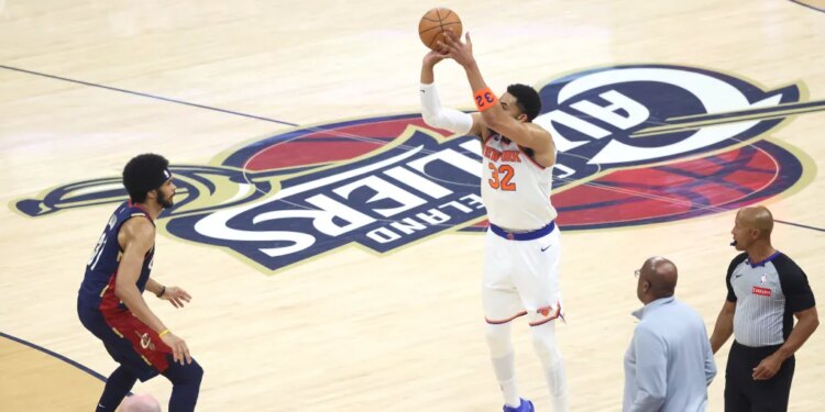 Karl-Anthony Towns (32) shooting a three-point shot over Jarrett Allen (31).