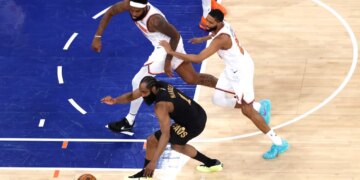 Cleveland Cavaliers guard James Harden (1), New York Knicks center Mitchell Robinson (23), and New York Knicks guard Mikal Bridges (25) chase a loose basketball on the court.