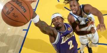 Jared Vanderbilt of the Lakers reaching for a basketball as Jonathan Kuminga of the Warriors defends.