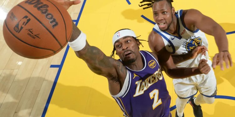 Jared Vanderbilt of the Lakers reaching for a basketball as Jonathan Kuminga of the Warriors defends.