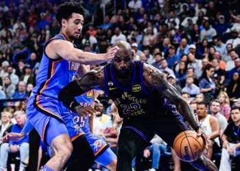 LeBron James drives past Jared McCain in an NBA game.