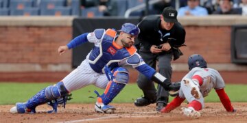 New York Mets catcher Luis Torrens tagging out Washington Nationals second baseman Nasim Nunez at home plate.