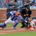 New York Mets catcher Luis Torrens tagging out Washington Nationals second baseman Nasim Nunez at home plate.
