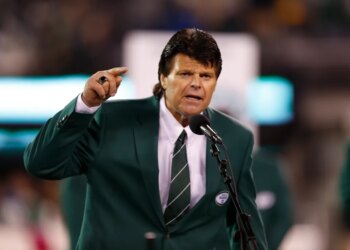 Mark Gastineau gestures while speaking into a microphone.