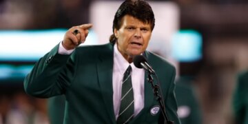Mark Gastineau gestures while speaking into a microphone.