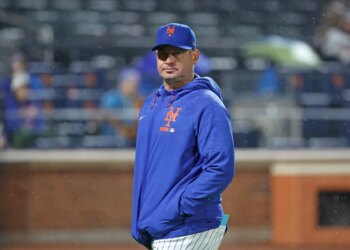 New York Mets manager Carlos Mendoza walks back to the dugout during a game.