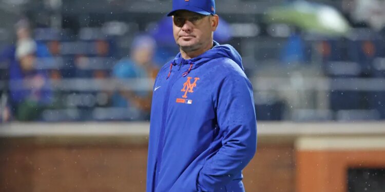 New York Mets manager Carlos Mendoza walks back to the dugout during a game.