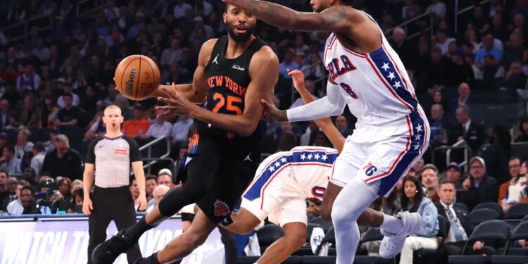 New York Knicks guard Mikal Bridges drives the ball past Philadelphia 76ers forward Paul George.