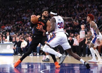 New York Knicks center Karl-Anthony Towns #32 drives to the basket as Philadelphia 76ers center Adem Bona #30 gives chase during the third quarter.