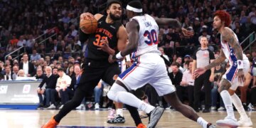 New York Knicks center Karl-Anthony Towns #32 drives to the basket as Philadelphia 76ers center Adem Bona #30 gives chase during the third quarter.