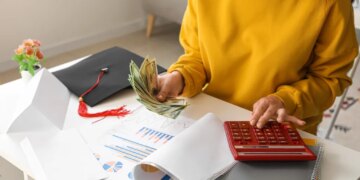 Female student calculating finances and holding dollar banknotes.