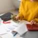Female student calculating finances and holding dollar banknotes.