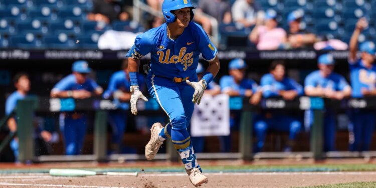 A baseball player in a blue UCLA uniform runs across the field.