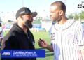 Odell Beckham Jr. being interviewed by a man in a baseball jersey on a sports field.