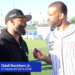 Odell Beckham Jr. being interviewed by a man in a baseball jersey on a sports field.
