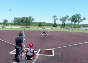 Baseball game in progress with a batter at home plate, a pitcher on the mound, and other players on the field.