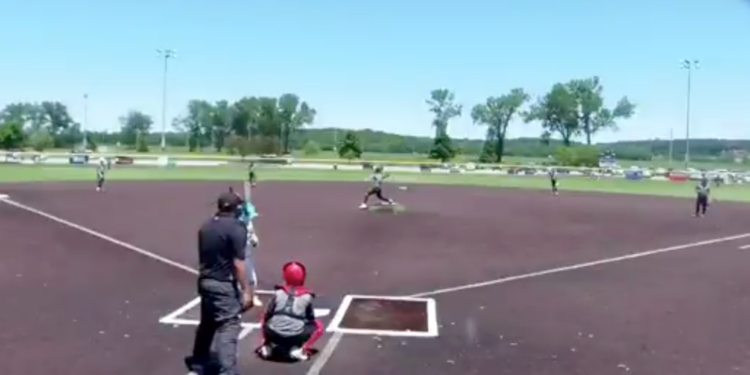 Baseball game in progress with a batter at home plate, a pitcher on the mound, and other players on the field.