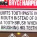 A scoreboard displays "BRYCE HARPER" in red and a white sign below it with black text that reads "SQUIRTS TOOTHPASTE INTO HIS MOUTH INSTEAD OF ONTO A TOOTHBRUSH WHEN BRUSHING HIS TEETH."
