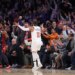 New York Knicks guard Jalen Brunson #11 celebrating a 3-point shot against the Cleveland Cavaliers, with fans cheering in the background.