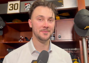 Man being interviewed in a locker room with a "30" sign in the background.