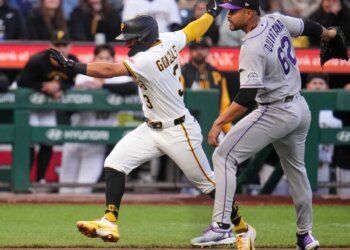 Pittsburgh Pirates' Nick Gonzales running past Colorado Rockies pitcher Jose Quintana in a rundown.