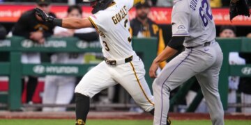 Pittsburgh Pirates' Nick Gonzales running past Colorado Rockies pitcher Jose Quintana in a rundown.