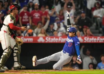 Shohei Ohtani sliding into a base as Logan O'Hoppe stands ready to catch.