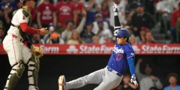 Shohei Ohtani sliding into a base as Logan O'Hoppe stands ready to catch.