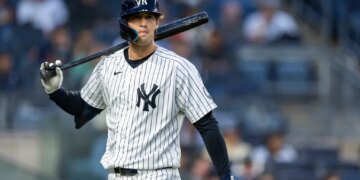 Spencer Jones of the New York Yankees on the field with a bat over his shoulder.