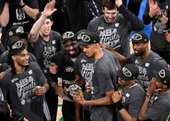 Victor Wembanyama, holding the Western Conference MVP trophy he won, celebrates with teammates after the Spurs' 111-103 Game 7 win over the Thunder on May 30, 2026 in Oklahoma City.