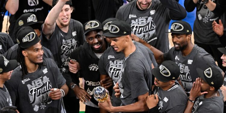 Victor Wembanyama, holding the Western Conference MVP trophy he won, celebrates with teammates after the Spurs' 111-103 Game 7 win over the Thunder on May 30, 2026 in Oklahoma City.