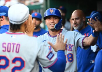 New York Mets left fielder Tyrone Taylor (28) is congratulated by teammates after scoring a run.